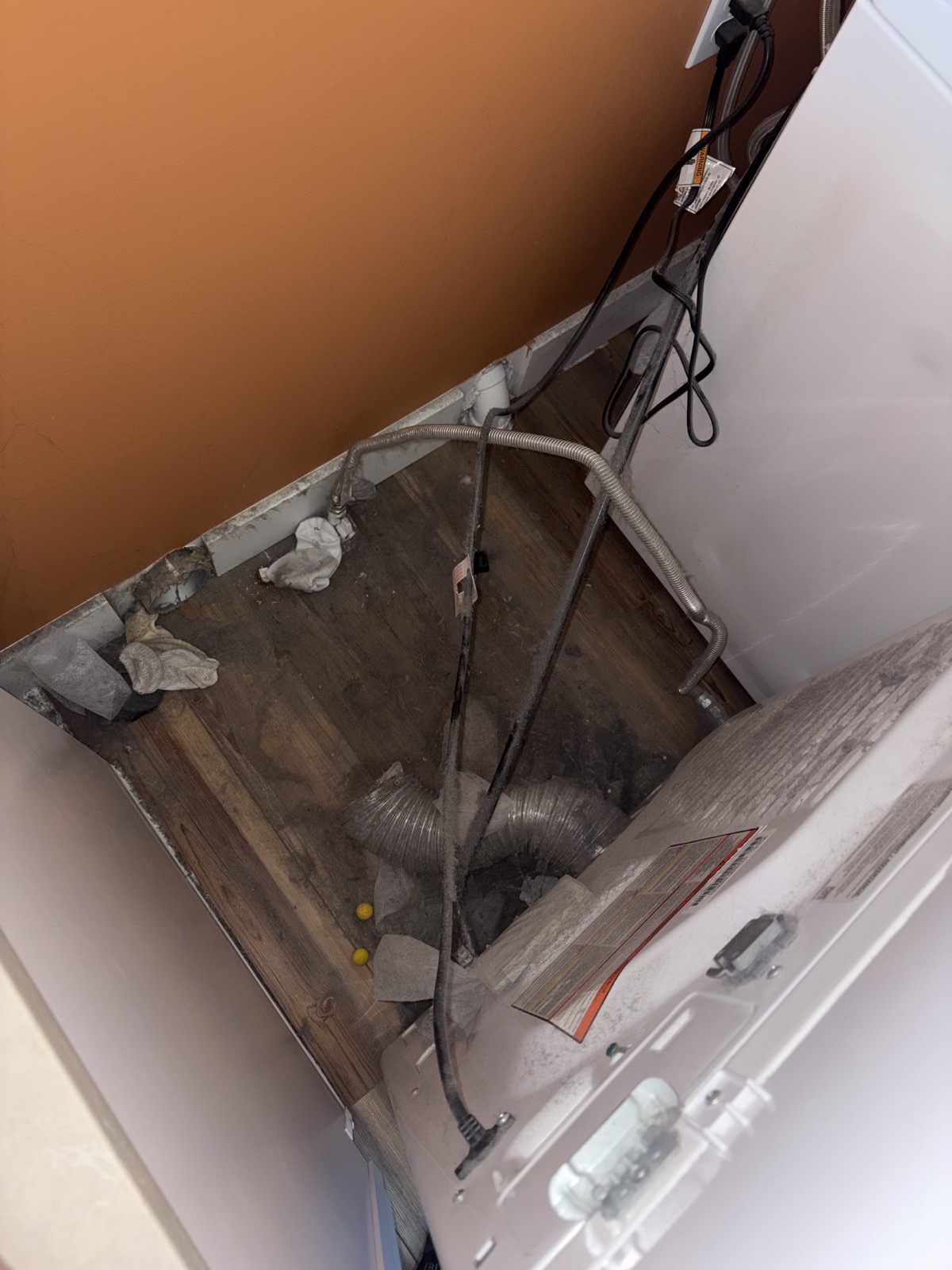 Dust and lint buildup behind a dryer before cleaning